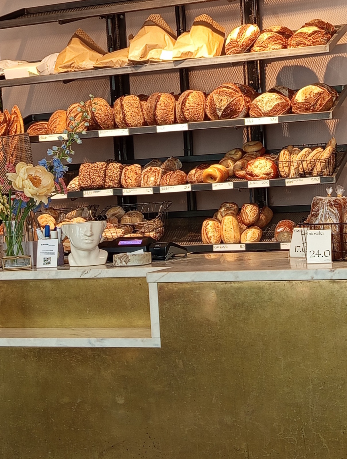 Regały ze świeżym pieczywem i chlebami na zakwasie w inna.piekarnia