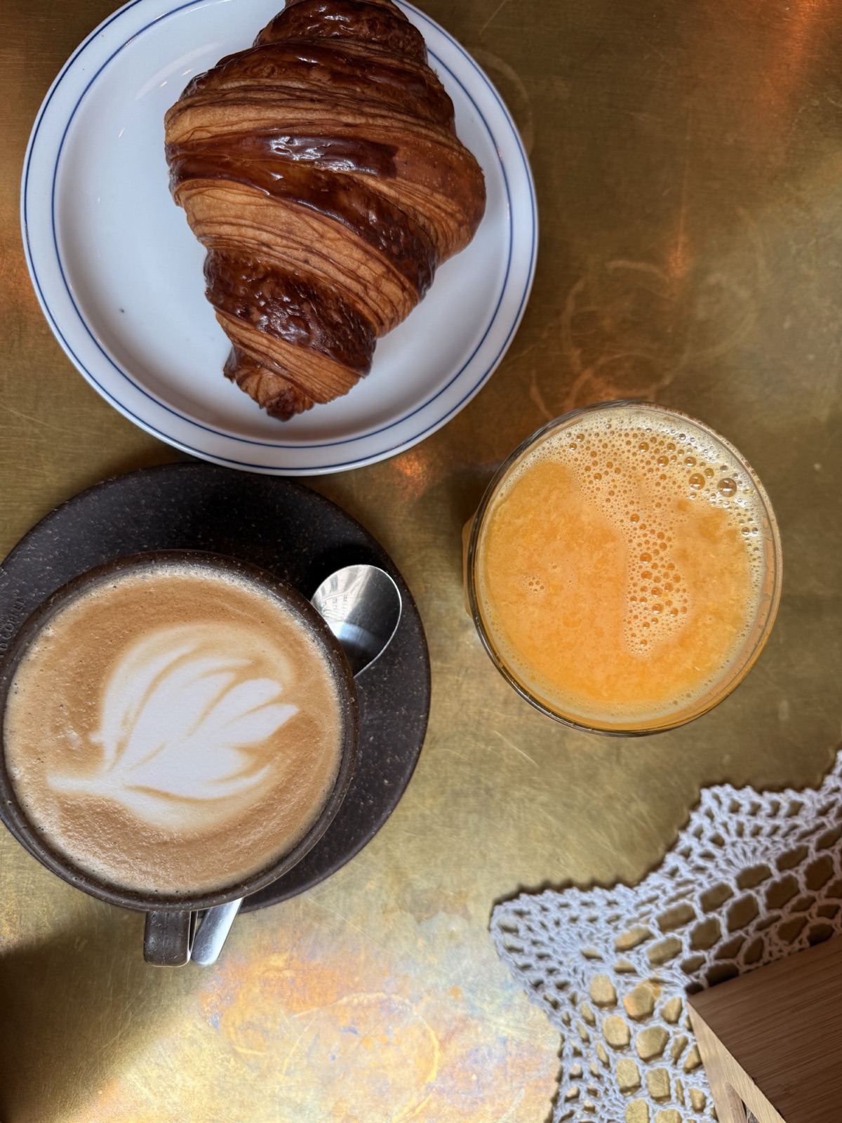 Croissant, kawa i sok na złotym blacie